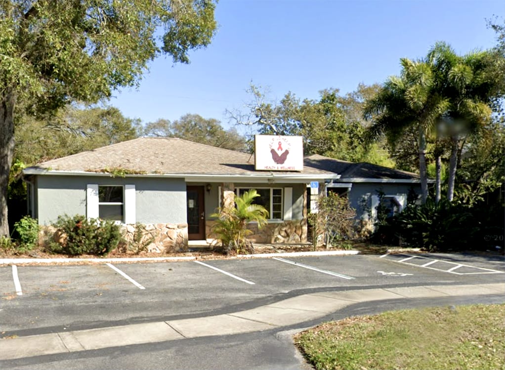 Help-Us Help-U community office building exterior with palm trees in St. Petersburg, Florida
